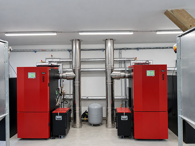 Dva červené biomasové kotle VERNER A602 v kotelně výrobního závodu BOULIT v Jirkově